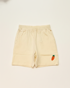 Beige shorts with a small embroidered design on a light beige background
