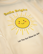 Beige sweatshirt with a smiley sun graphic and text on a beige background