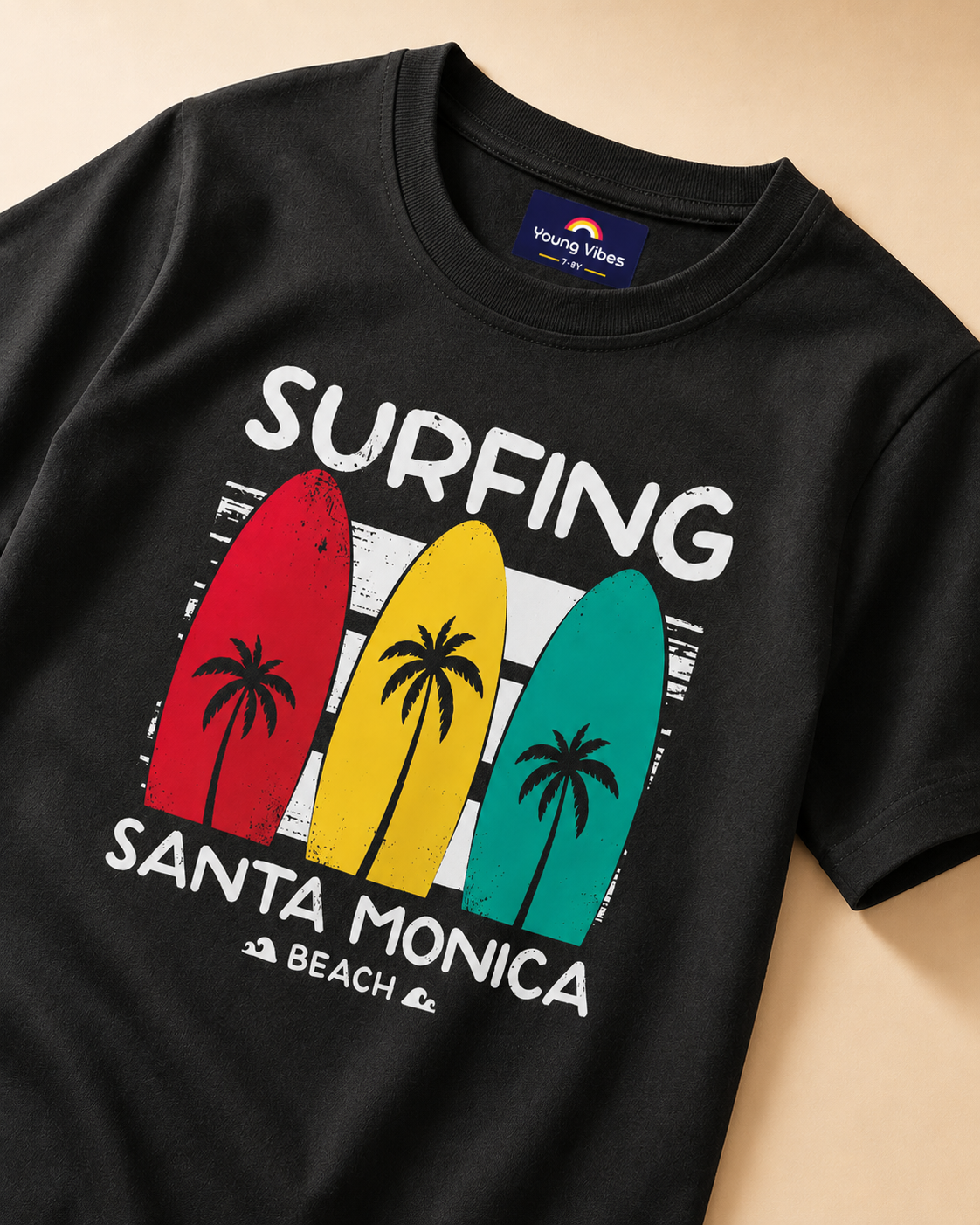 Black T-shirt with surfing beach  print placed in light beige background closeup view
