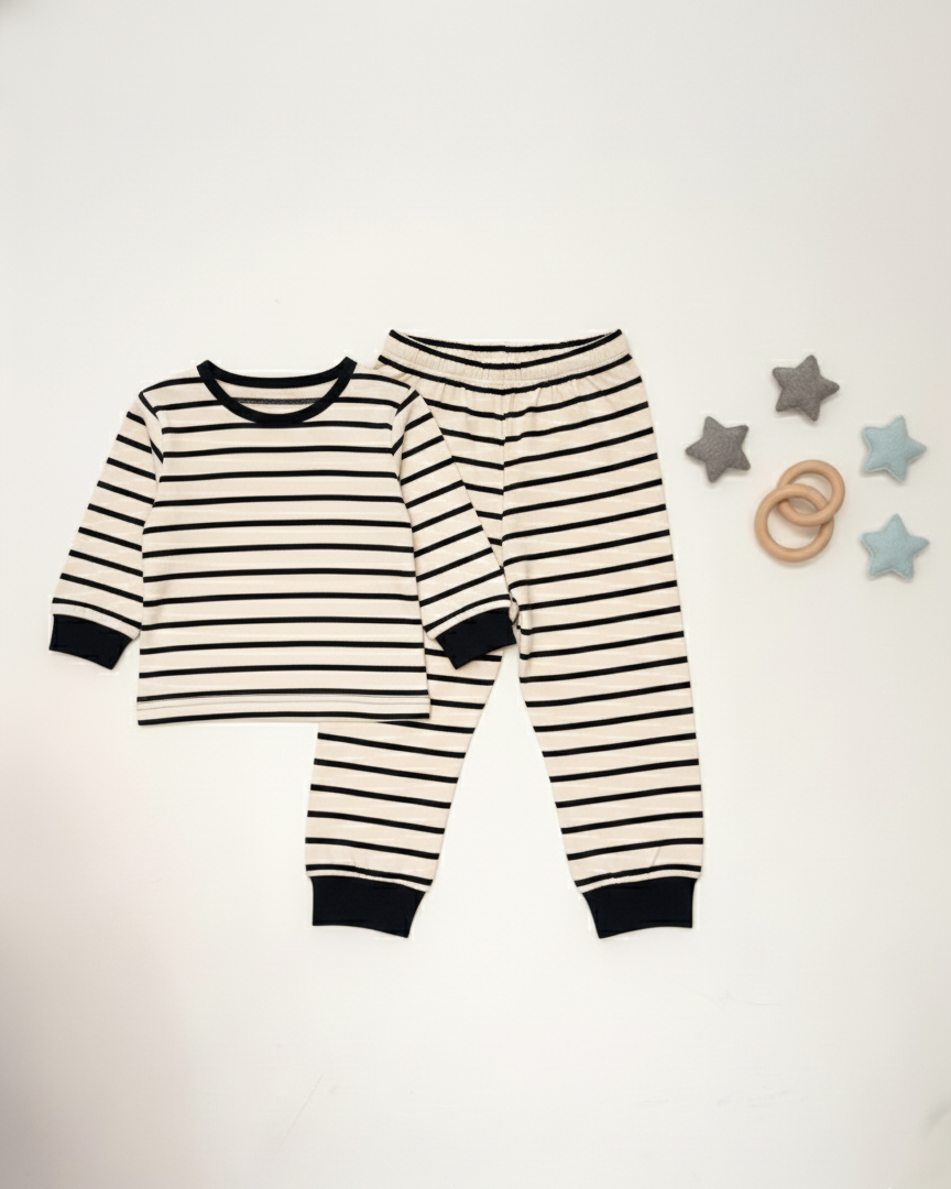 Black and white striped baby pajamas on a white background with star-shaped toys.