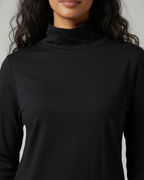 Black high neck shirt worn by a person against a neutral background