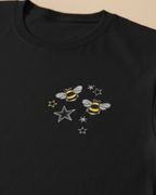 Black sweatshirt with bee and star embroidery on a beige background