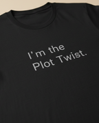 Black t-shirt with 'I'm the Plot Twist' text on a beige background