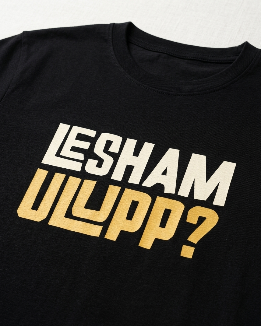 Black t-shirt with 'LESHAM ULYPP?' text in white and gold on a light gray background