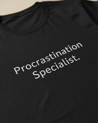 Black t-shirt with 'Procrastination Specialist' text on a plain background