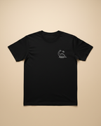 Black t-shirt with a small white logo on a beige background