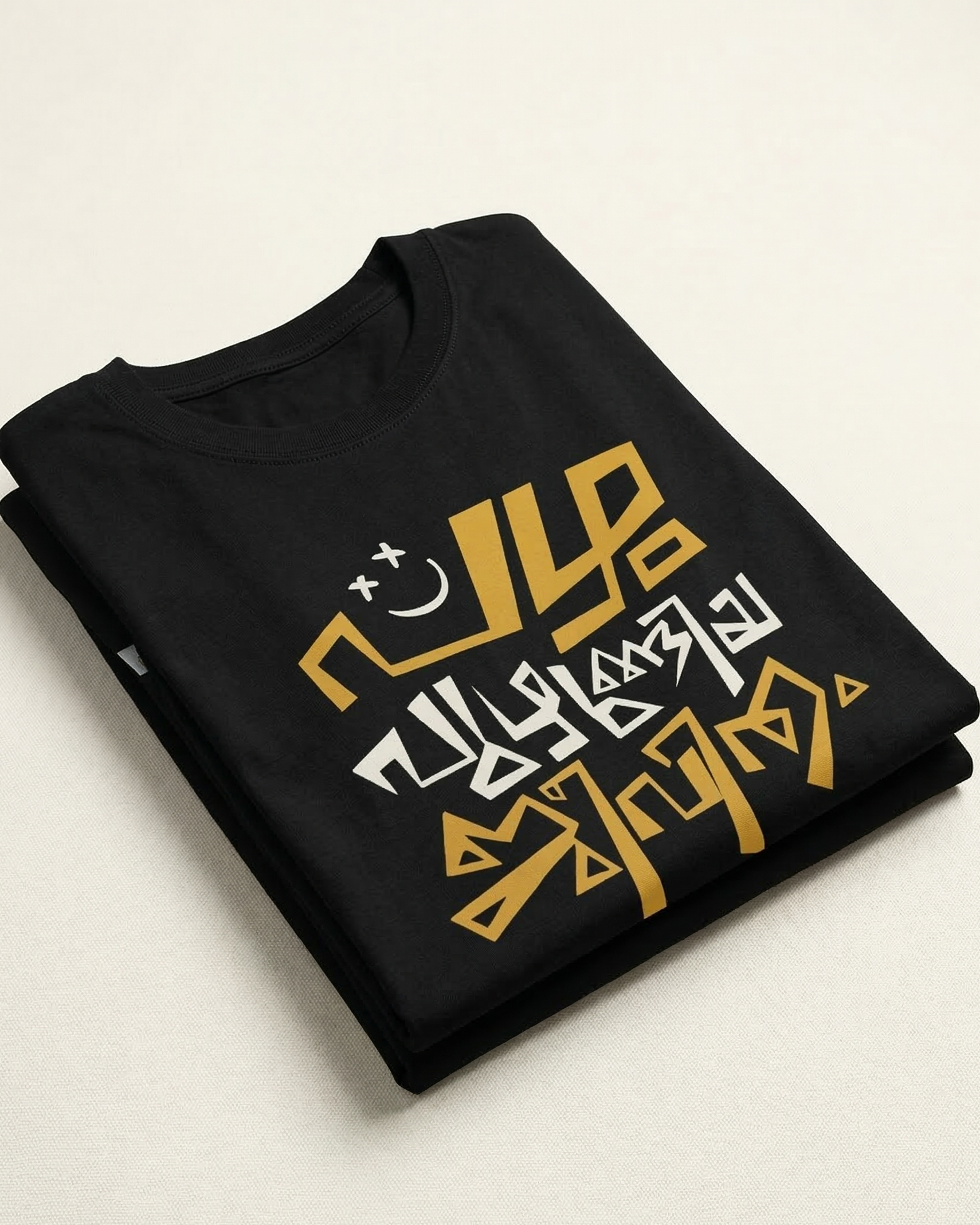 Black t-shirt with gold and white graphic design on a light beige background
