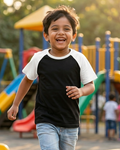 A boy wearing a Black with White Raglan Sleeve T-Shirt and playing in park .