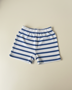 Blue and white striped shorts on a beige background