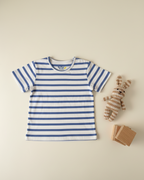 Blue and white striped t-shirt with a teddy bear and cards on a beige background