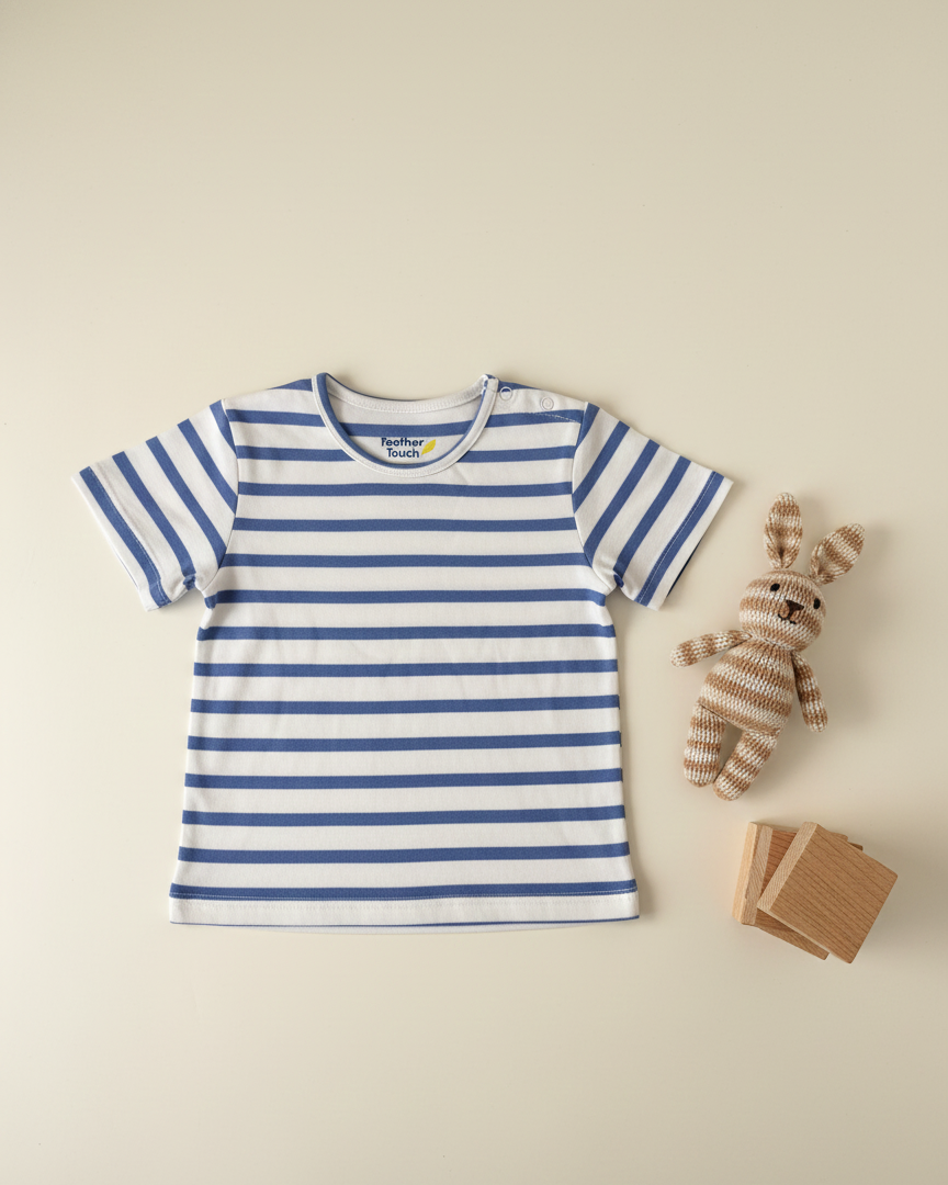 Blue and white striped t-shirt with a teddy bear and cards on a beige background