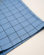 Blue fabric with a grid pattern on a light background