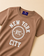 Close view of Brown T-shirt with NYC print placed on the light beige Background