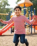 Child in a red and white striped shirt running on a playground