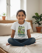 Child sitting on a bed wearing a t-shirt with cartoon characters and text.