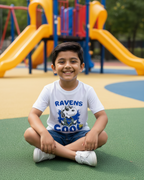 Child sitting on a playground with colorful slides and equipment in the background