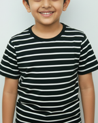 Child wearing a black and white striped shirt against a plain background
