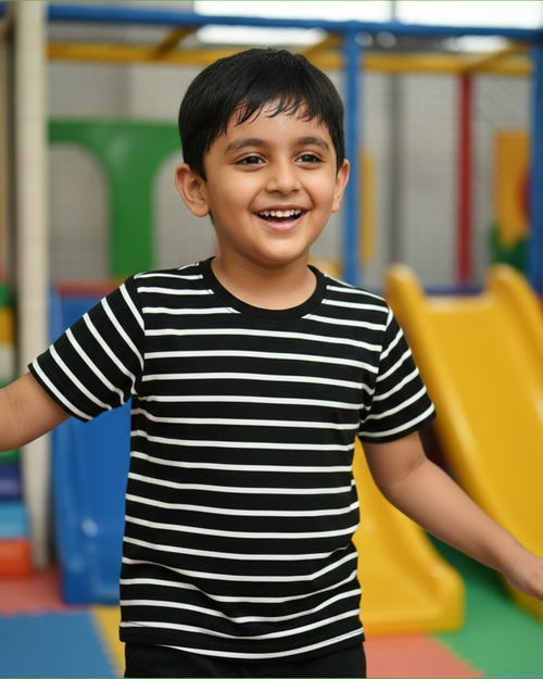 Child wearing a black and white striped shirt in an indoor playground.