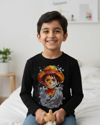 Child wearing a black long-sleeve T-shirt with a graphic design, sitting on a bed.
