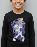 Child wearing a black long-sleeve shirt with a graphic design on a gray background