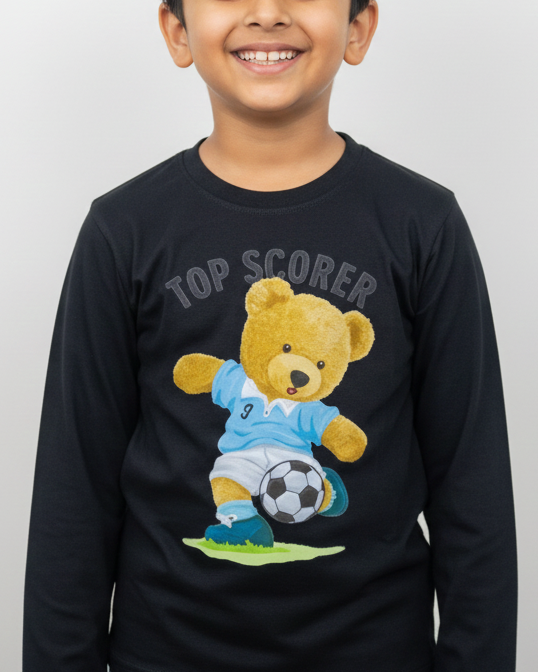 Child wearing a black long-sleeve shirt with a teddy bear graphic and 'Top Scorer' text on a white background