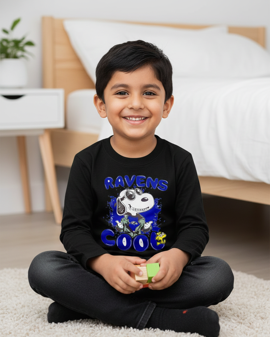 Child wearing a black shirt with a graphic design sitting on a carpeted floor.