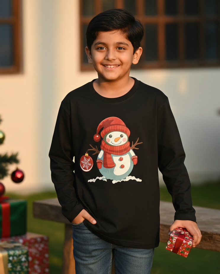 Child wearing a black sweater with a snowman design in front of a Christmas tree and presents.