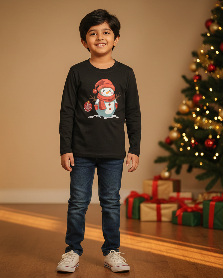Child wearing a black sweater with a snowman design in front of a decorated Christmas tree.