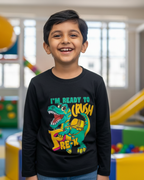 Child wearing a black sweatshirt with a colorful dinosaur graphic in a playroom.