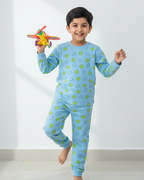 Child wearing a blue pajama set with green polka dots, holding a colorful star-shaped toy.