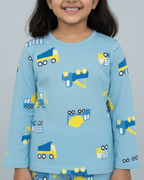 Child wearing a blue pajama set with vehicle patterns on a plain background