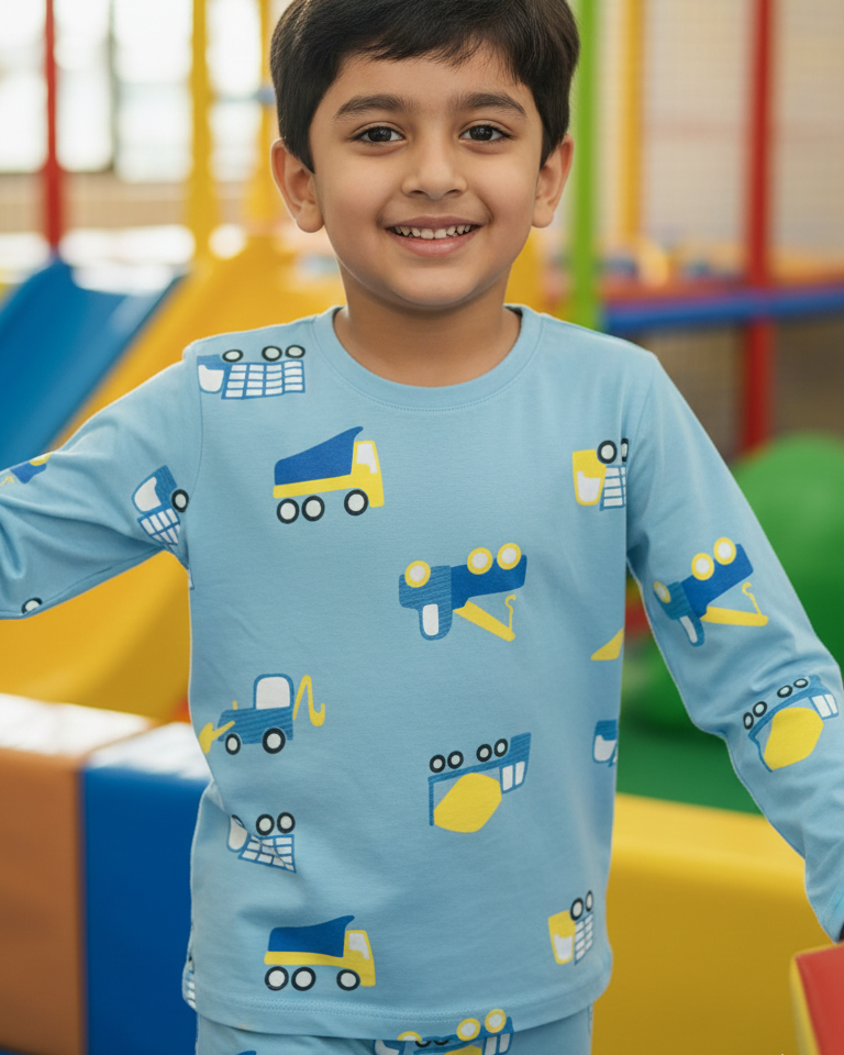 Child wearing a blue shirt with vehicle prints in an indoor playground setting
