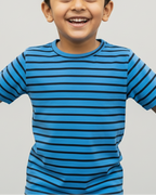 Child wearing a blue striped shirt against a gray background
