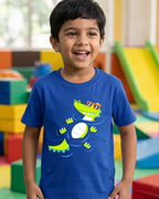 Child wearing a blue t-shirt with a colorful alligator design in a playroom.