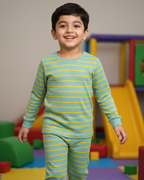 Child wearing a green and yellow striped outfit in a colorful playroom.