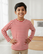 Child wearing a red and white striped shirt in a bedroom setting