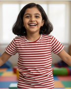 Child wearing a red and white striped shirt in a colorful playroom.