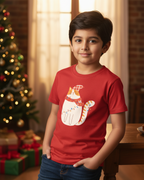 Child wearing a red t-shirt with a cat design in a festive setting with a Christmas tree and presents.