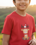 Child wearing a red t-shirt with a reindeer graphic outdoors
