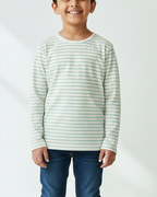 Child wearing a striped shirt and jeans on a white background