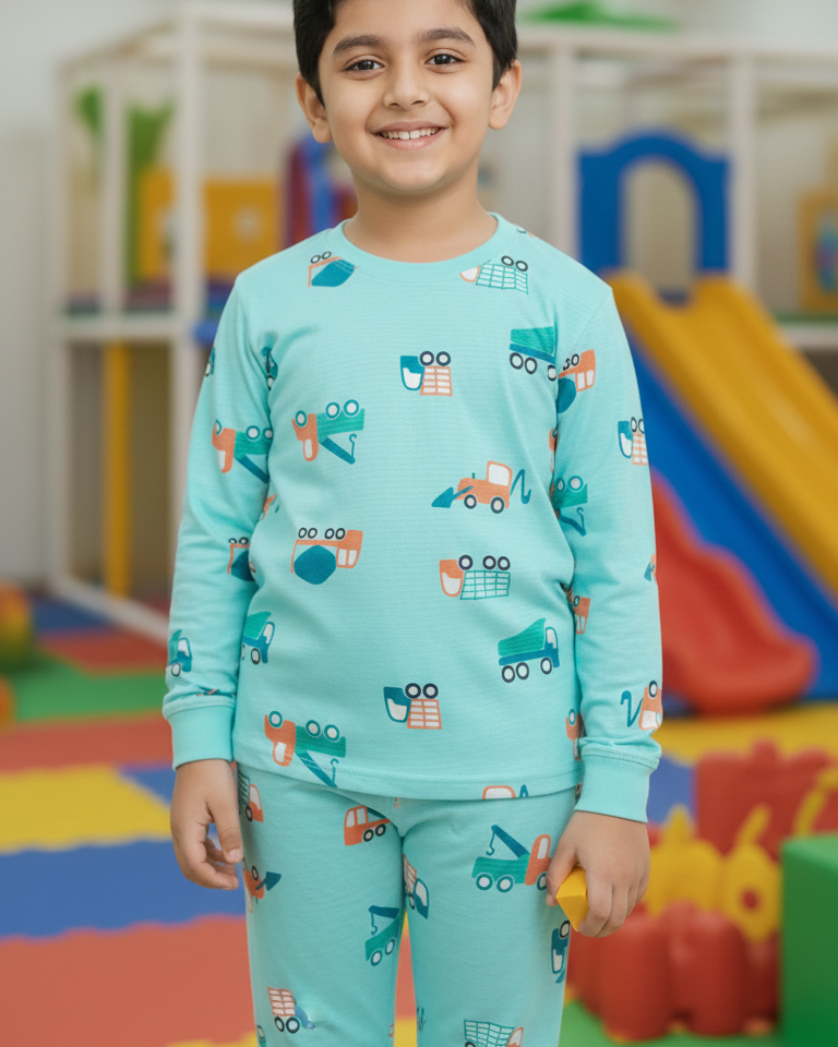 Child wearing a teal pajama set with car pattern in a colorful indoor playground.