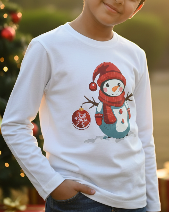 Child wearing a white long-sleeve shirt with a snowman design in front of a Christmas tree.