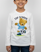 Child wearing a white long-sleeve shirt with a teddy bear graphic and 'Top Scorer' text on a plain background
