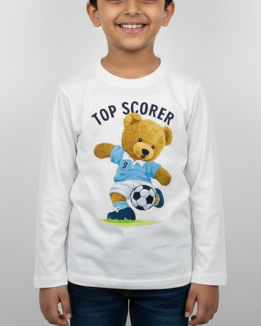 Child wearing a white long-sleeve shirt with a teddy bear graphic and 'Top Scorer' text on a plain background