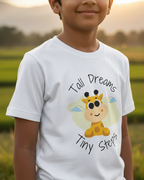 Child wearing a white t-shirt with a cartoon giraffe and text in a natural setting