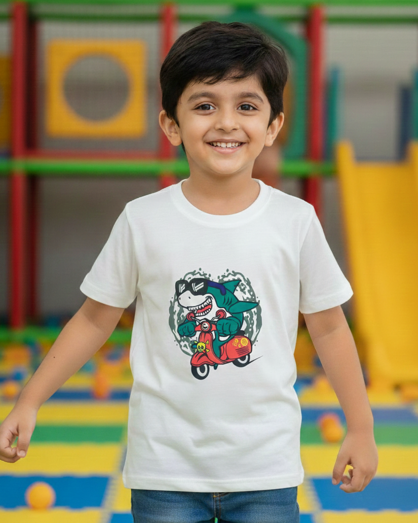 Child wearing a white t-shirt with a colorful graphic design in an indoor playground.