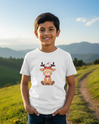 Child wearing a white t-shirt with a reindeer graphic in a scenic outdoor setting
