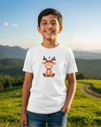 Child wearing a white t-shirt with a reindeer graphic in a scenic outdoor setting