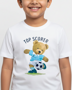 Child wearing a white t-shirt with a teddy bear holding a soccer ball and 'Top Scorer' text.