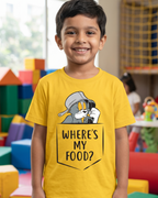 Child wearing a yellow t-shirt with a cartoon character and text if Tom saying where is my food in a colorful indoor setting